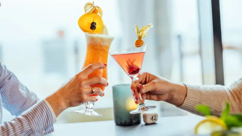 Cocktails A pair of hands holding glasses with cocktails.