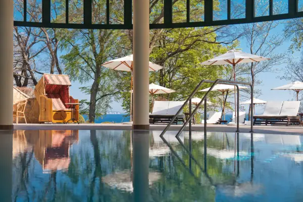 Ein Pool mit einem Liegestuhl und Sonnenschirmen.