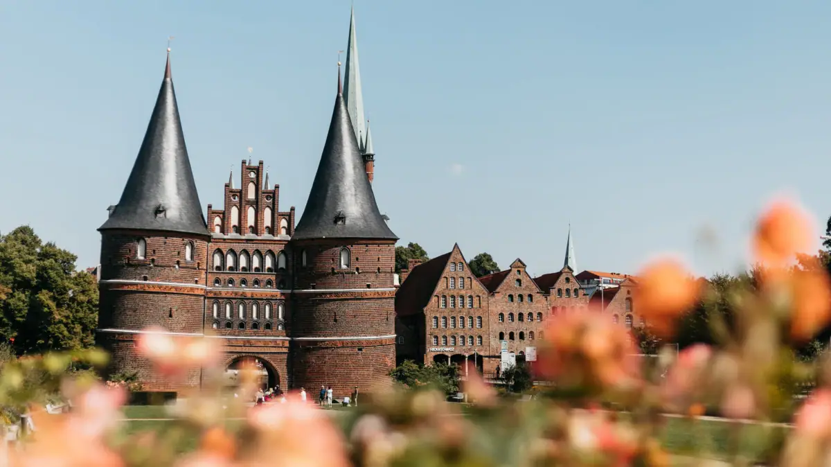 A building with towers and a lawn in the background.