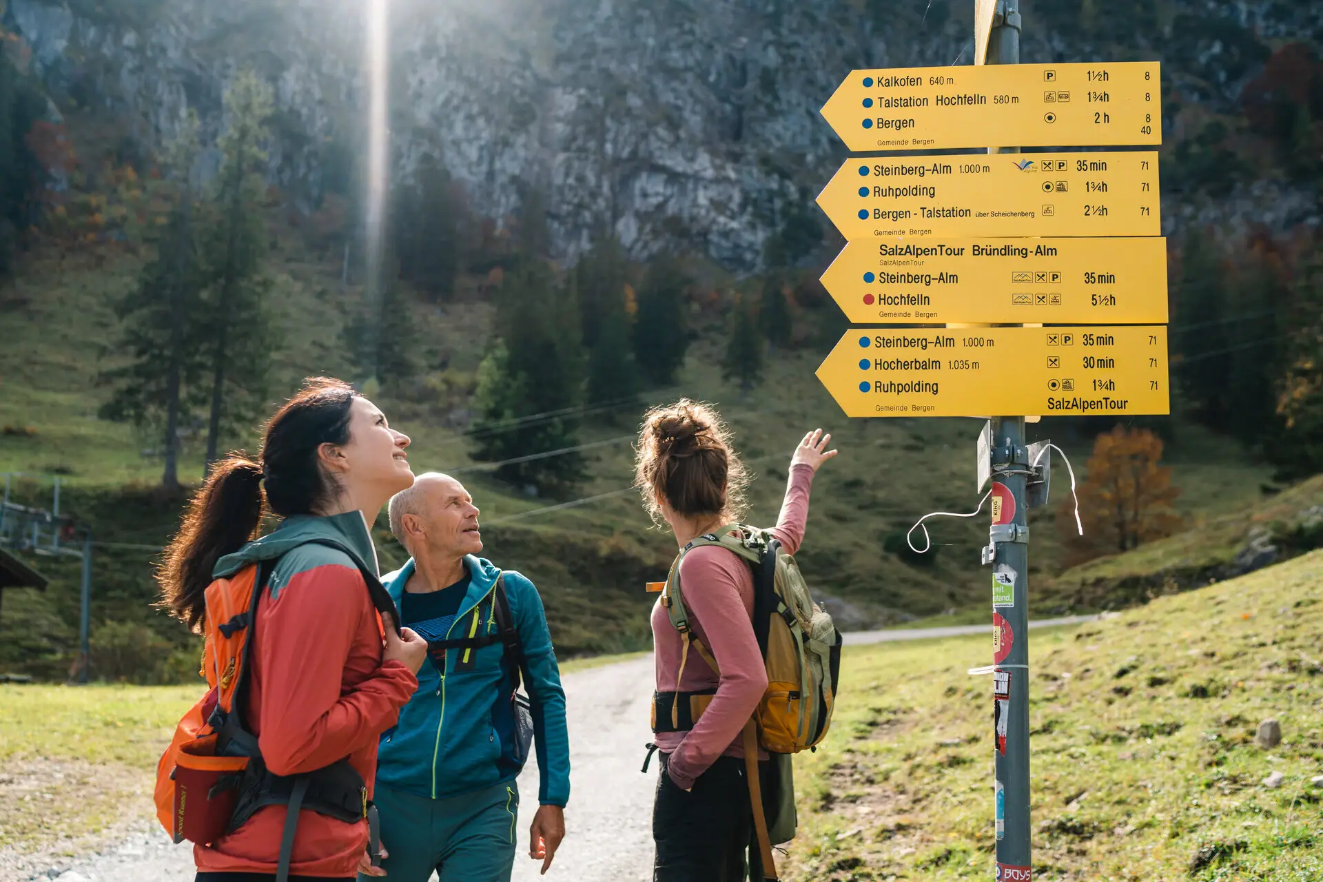 Mountain hike A group of people look at a sign outside.