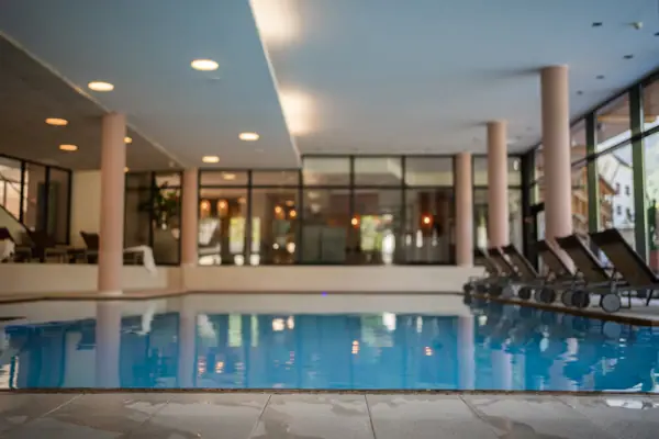 An indoor swimming pool in a building with water and a ceiling.