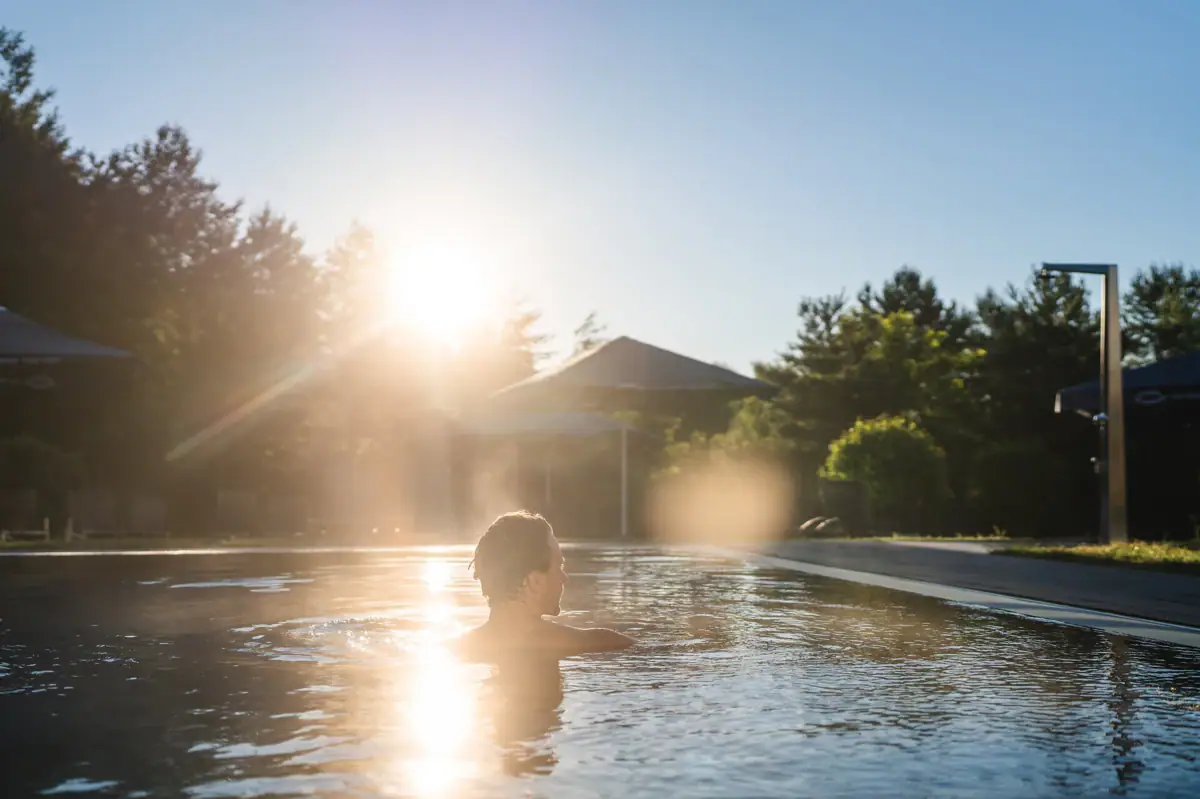 aja SPA A person in a pool on which the sun is shining.