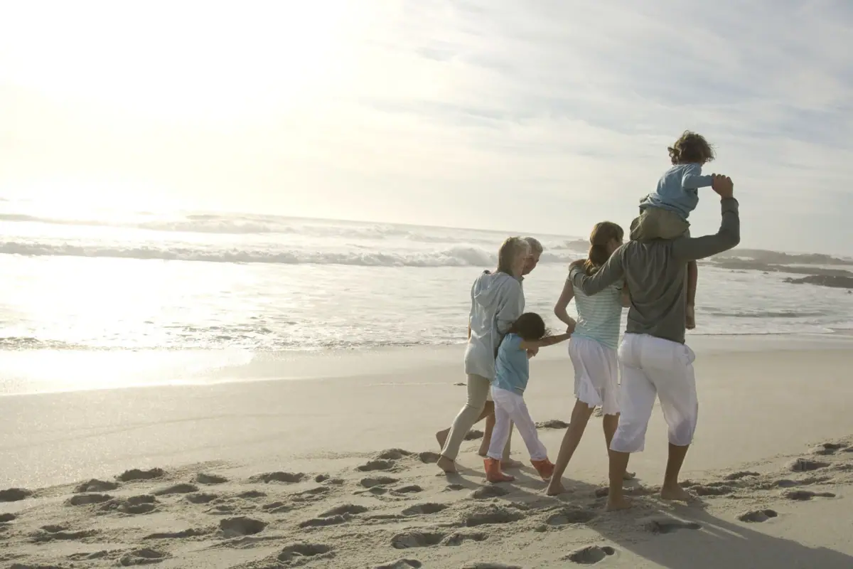 A family strolls along the beach.