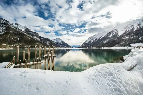 Snow-covered mountain and lake in a wintry landscape.