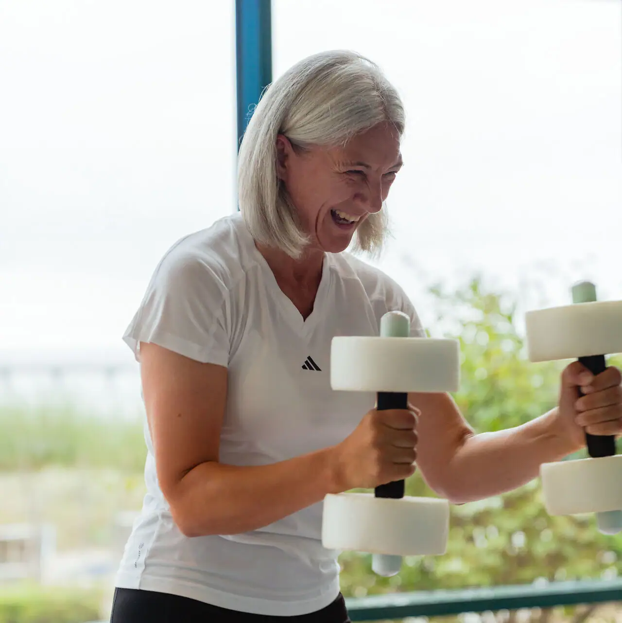 Aqua Fitness A woman lifting weights in a gym.