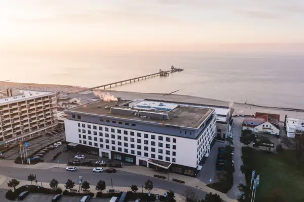 Ein Gebäude neben einem Gewässer unter einem bewölkten Himmel.