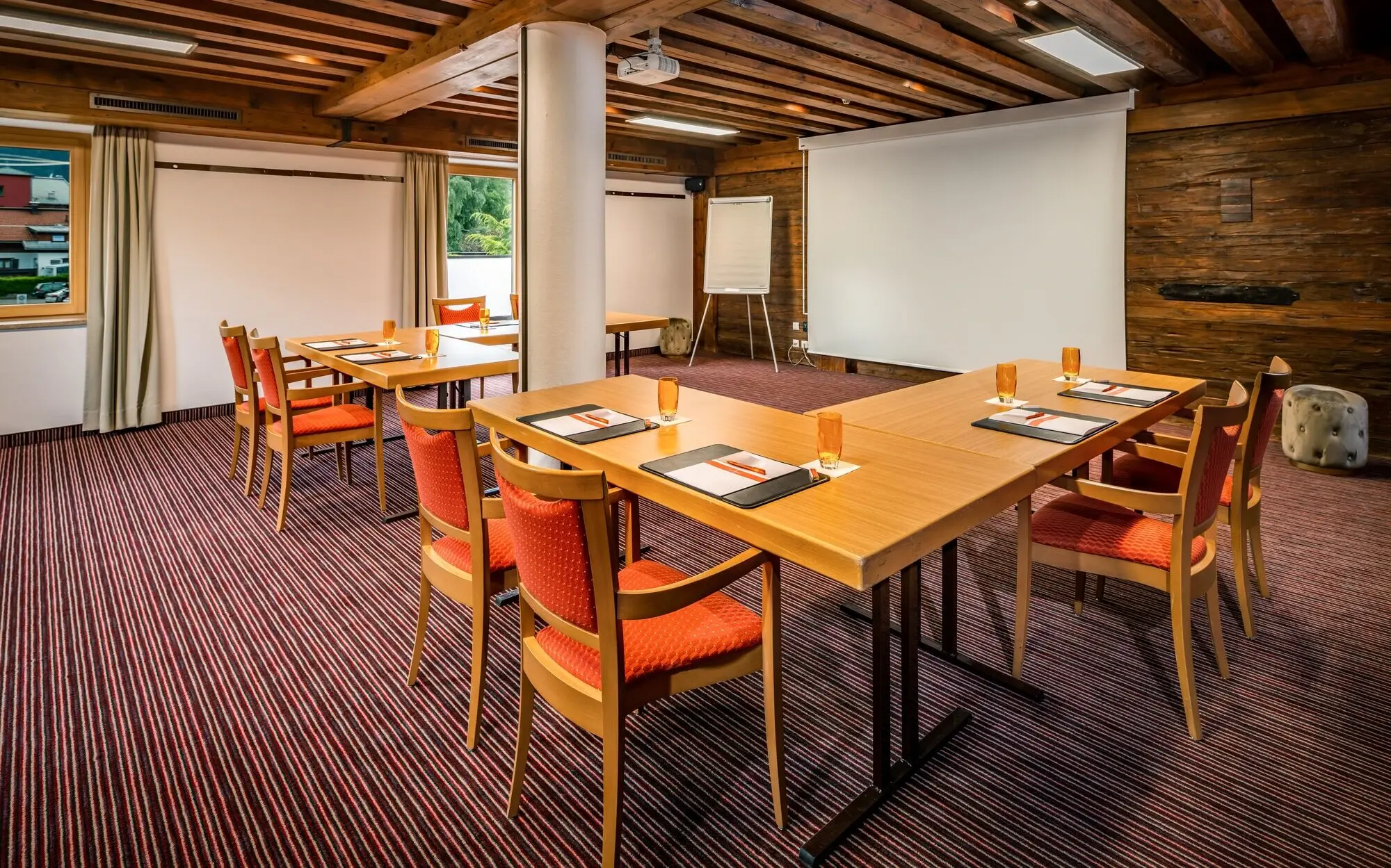 Meeting room with tables, chairs and a screen.