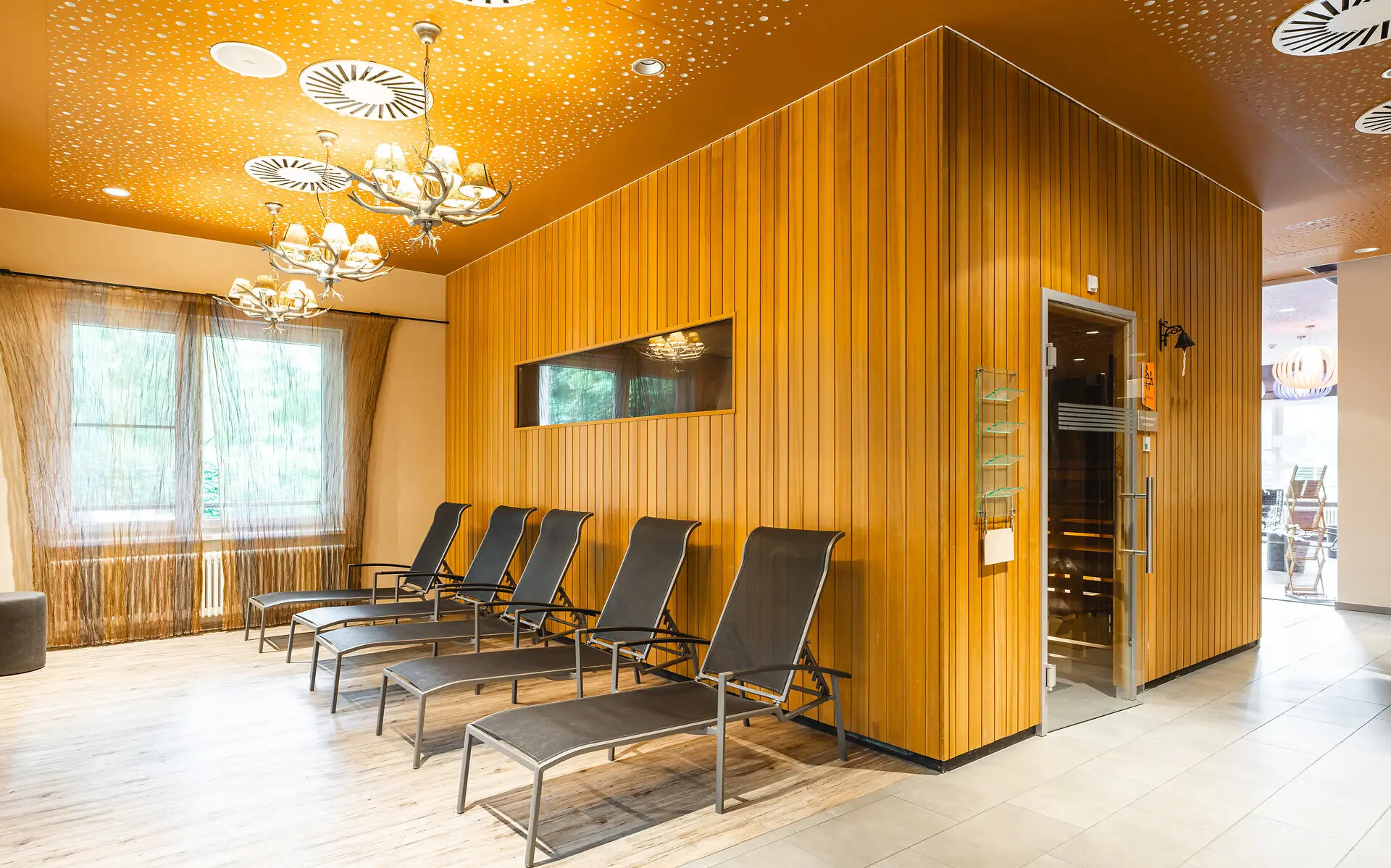 Interior view of a room featuring multiple chairs and a door, with detailed flooring and ceiling design.