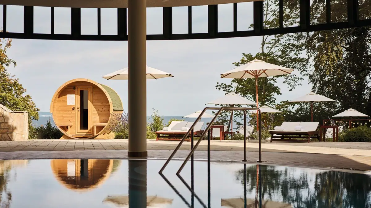 A pool with parasols and a barrel.