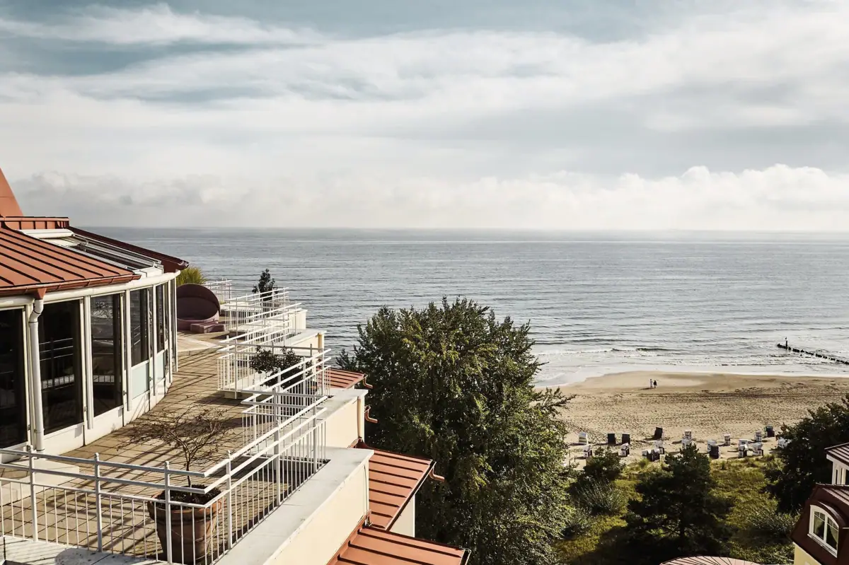 A beach with a building and a body of water.