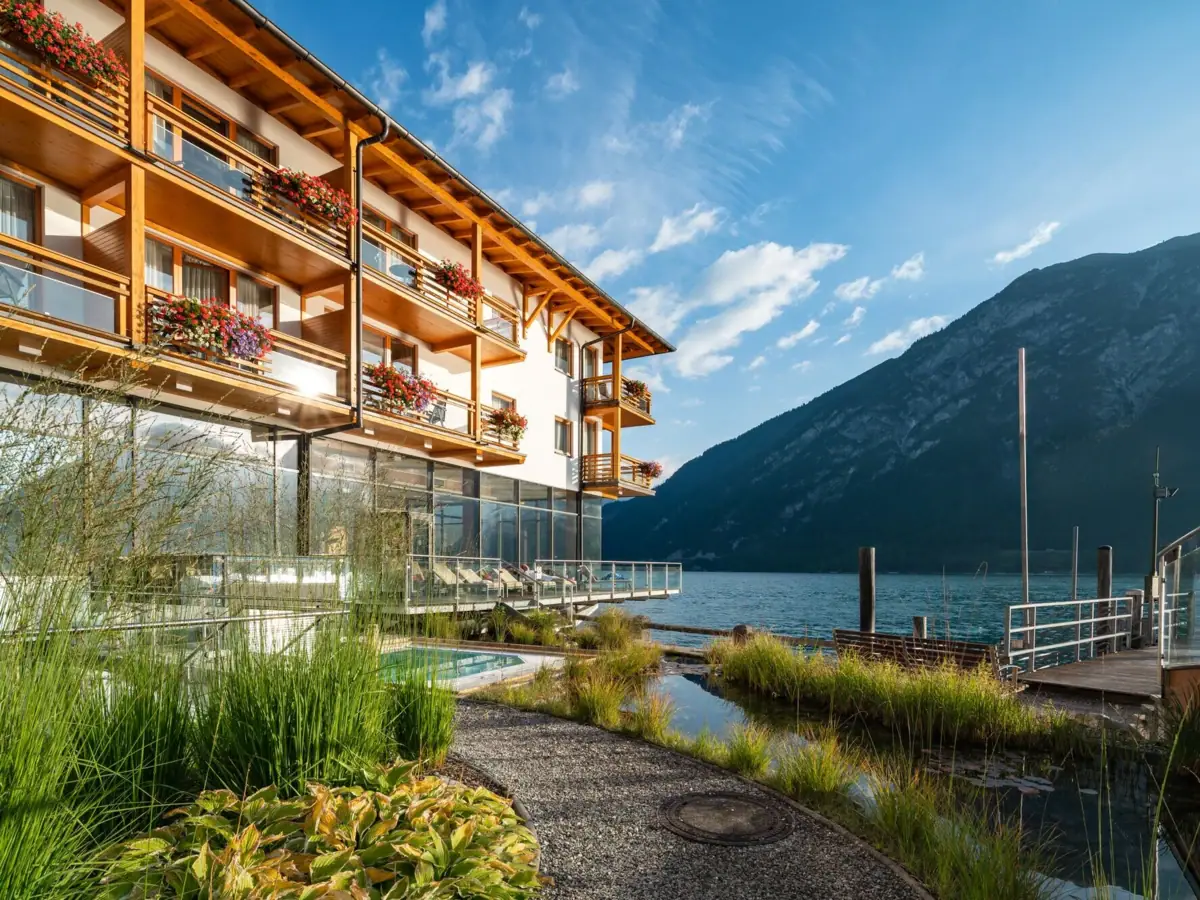Princely house on Lake Achensee A building with a lake and mountains in the background.