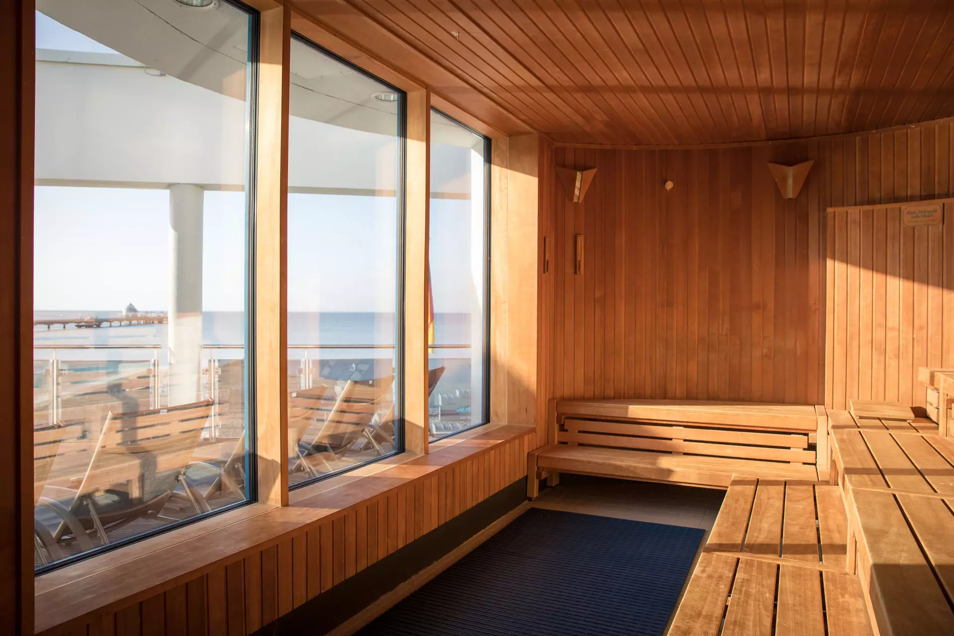 Sauna room with wooden walls and windows overlooking the beach