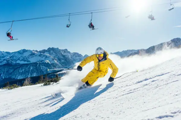 A person skis down a snow-covered mountain.