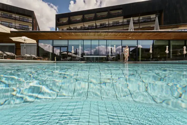 Ein Schwimmbecken mit dem Hotel im Hintergrund.