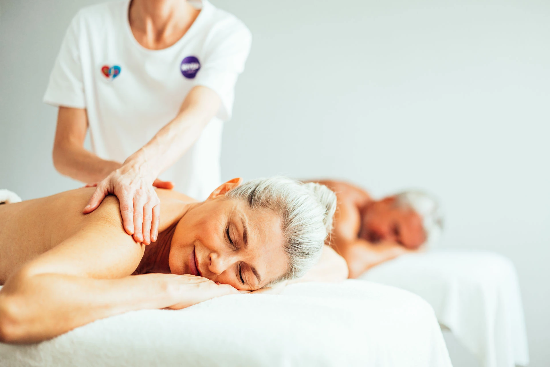 Couples massage A woman and a man are lying on a bed.