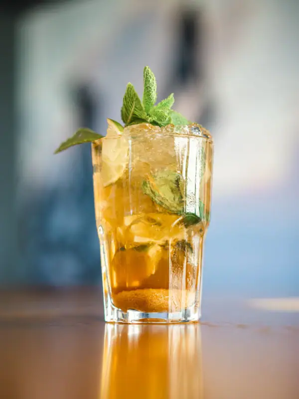 Drink at aja Warnemünde A glass with a cocktail and mint leaves.