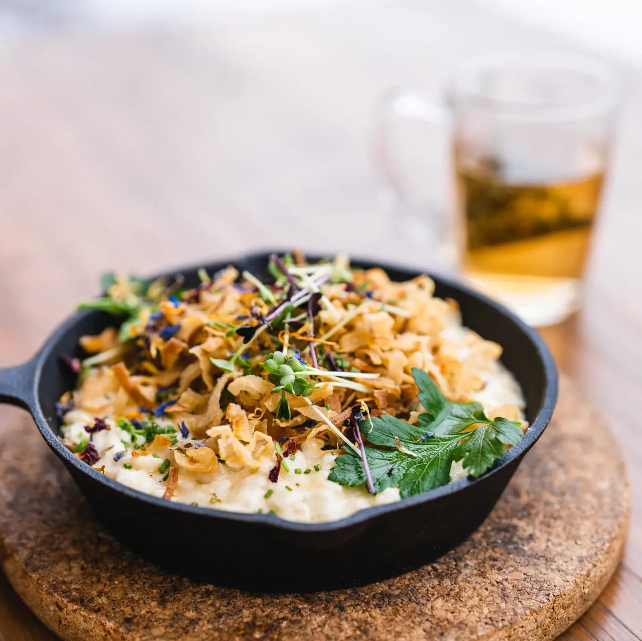 Cheese spaetzle A pan with food on a table.