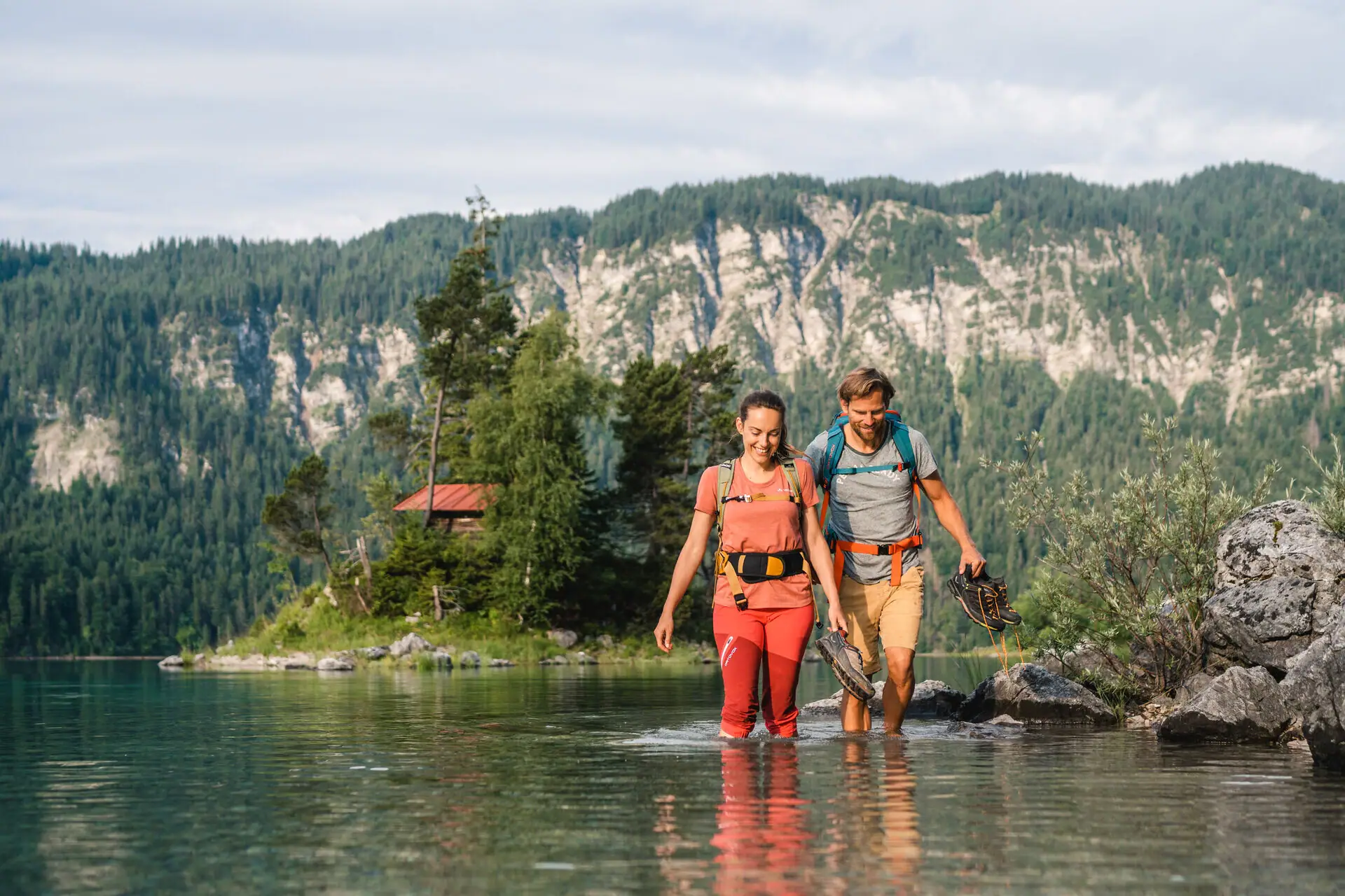 Hiking at the Eibsee A man and a woman walking in the water.
