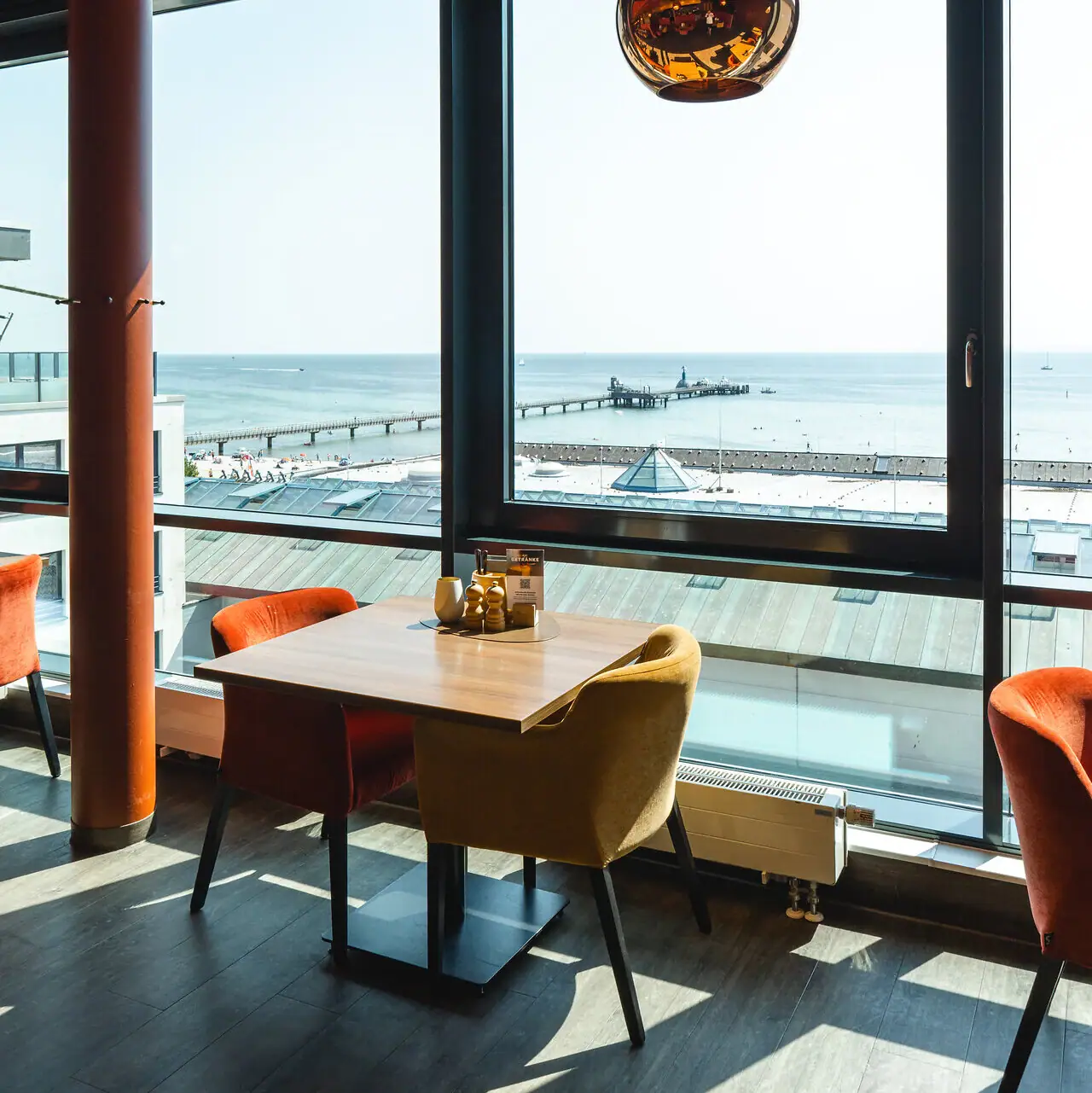 A table and chairs in a room overlooking the ocean.