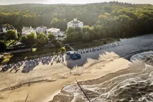 Ein Strand mit vielen Strankörben und Bäumen.