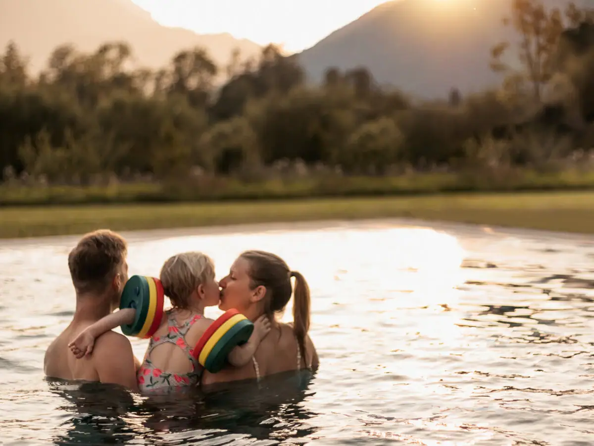Family in the pool A group of people in the pool, a child gives a kiss.