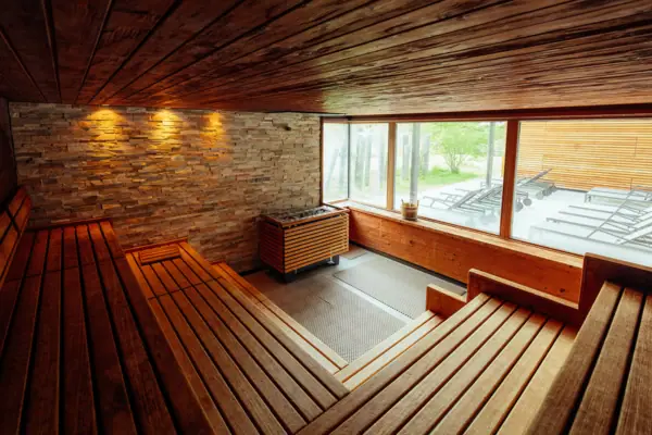 A room with a wooden bench and a stone wall.