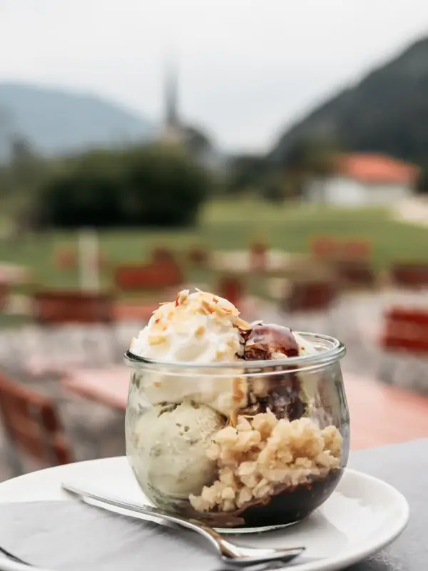Glass bowl with ice cream and fork on a table