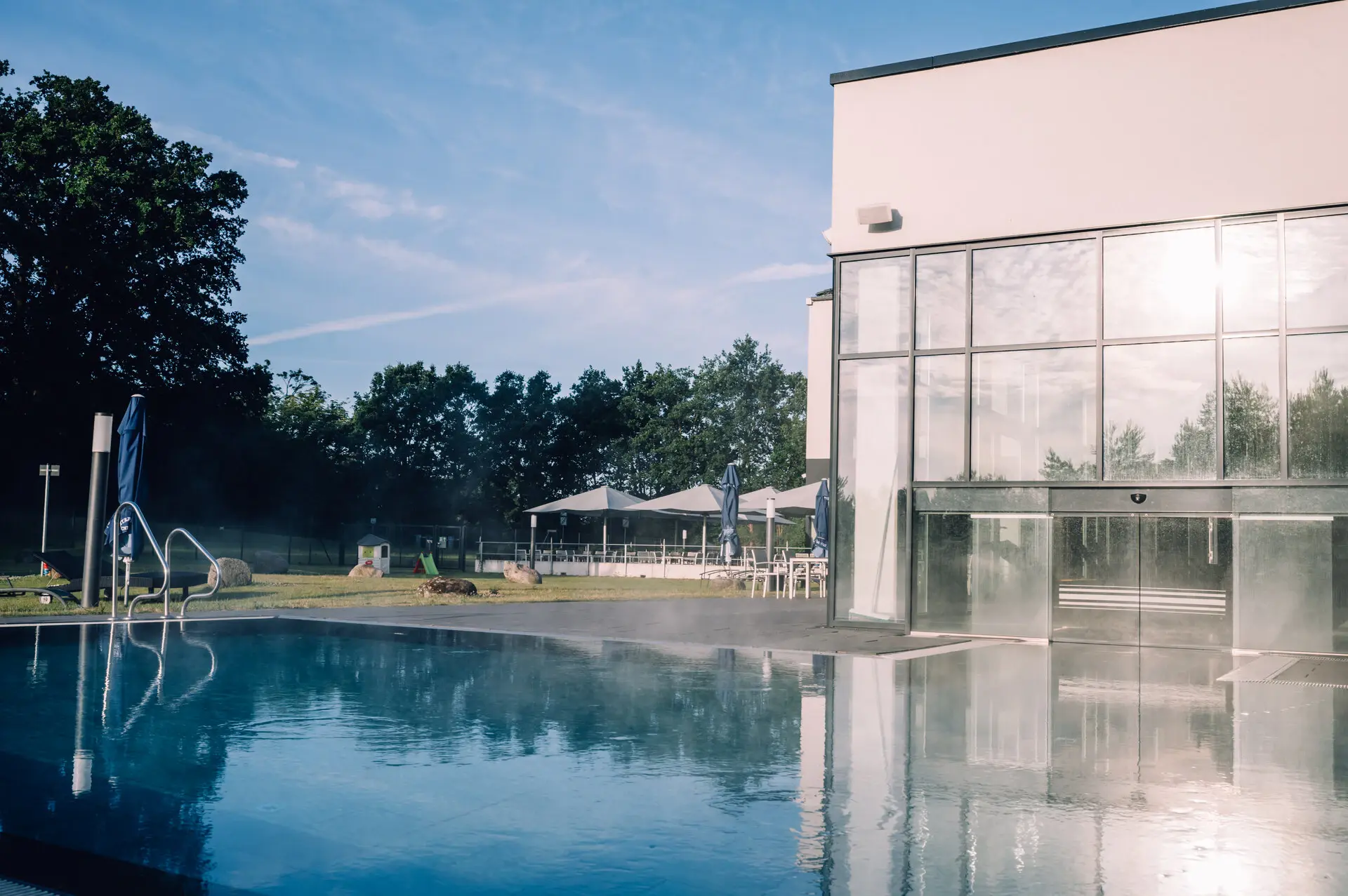 An outdoor pool with clear water in front of a building