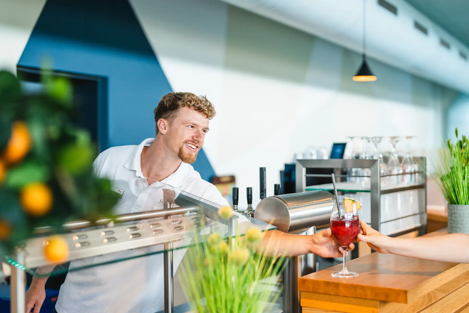 A man hands a woman a drink.