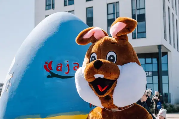 Person in a bunny costume next to an egg