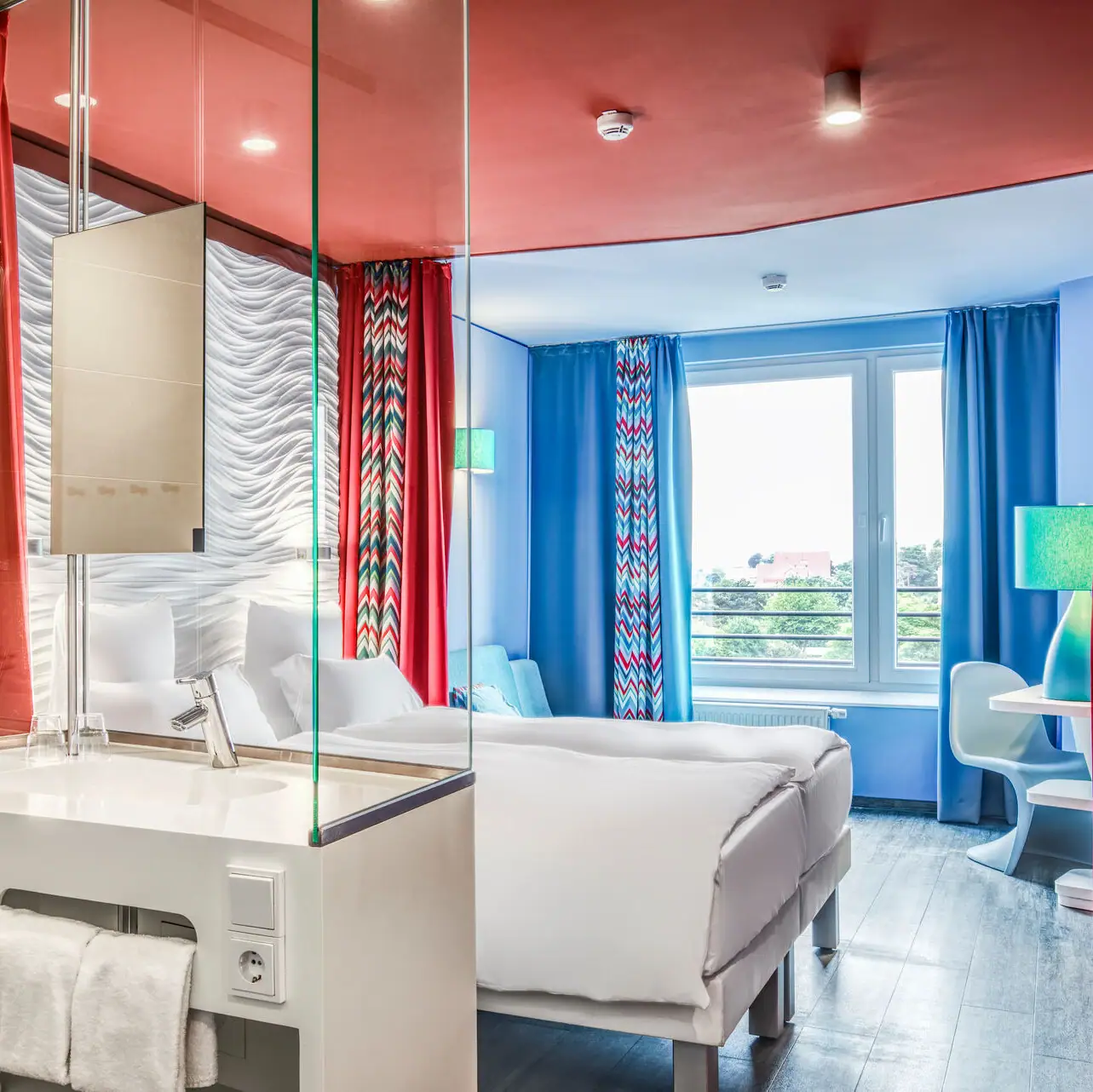 A room with a double bed and a washbasin.