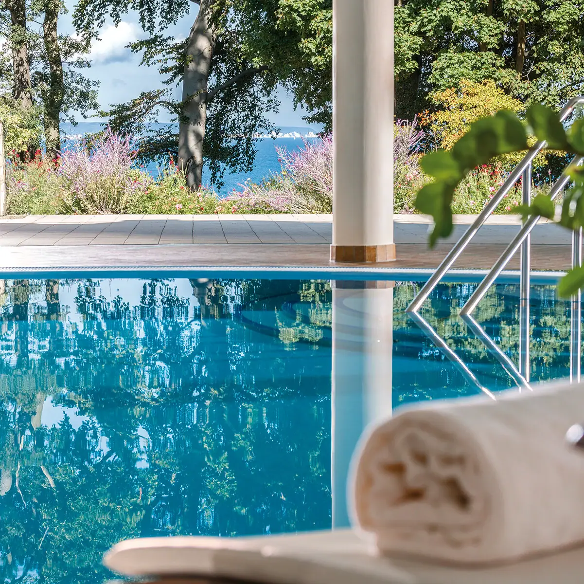 Pool Nordperd & Villas A pool with a towel and a railing.