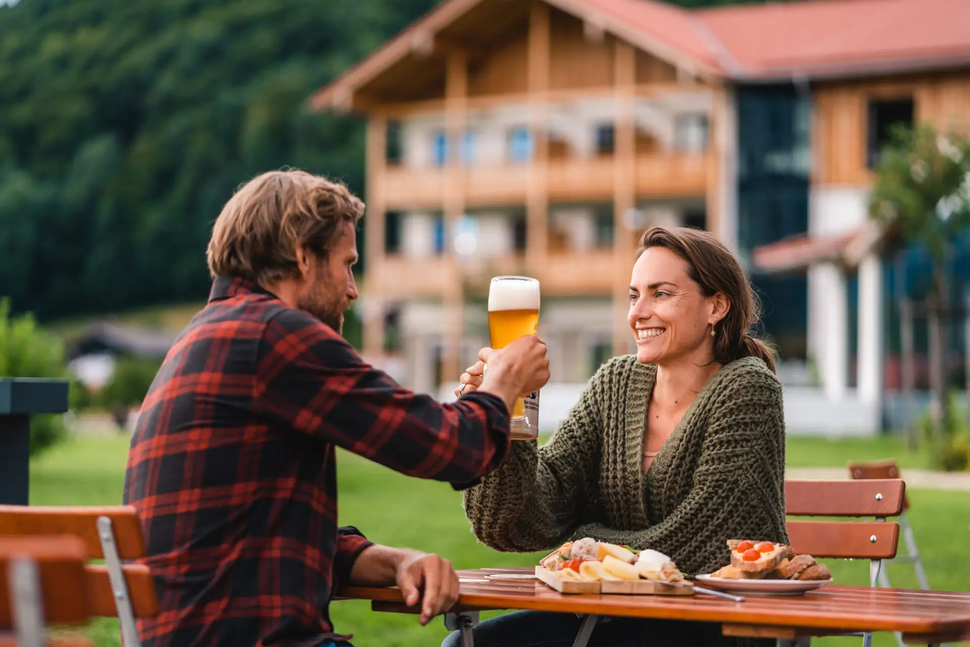 Beer garden A man and a woman are sitting at a table with food and drinks.