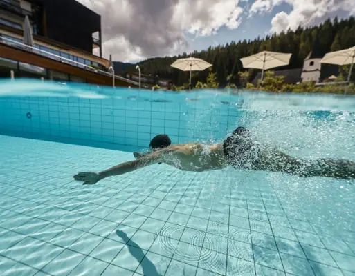 A man dives in the outdoor pool at the aja Werfenweng.