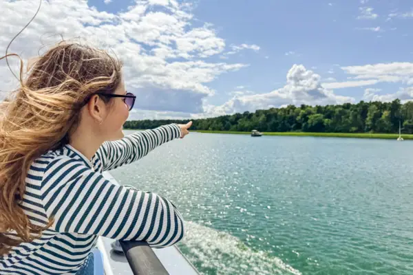 A woman points to a body of water.