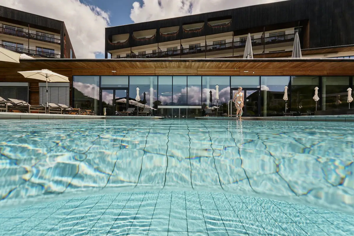 The outdoor swimming pool with the hotel building in the background.