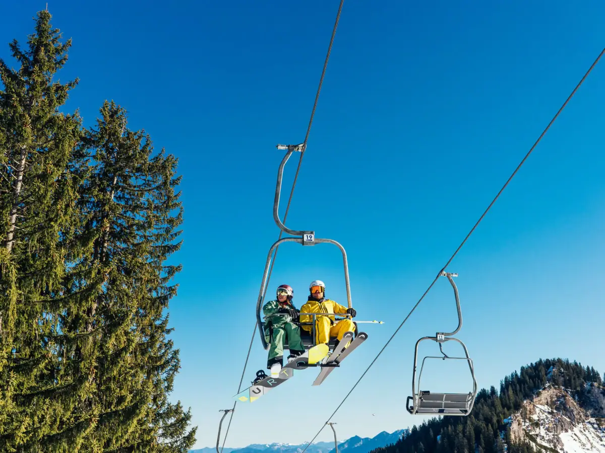 Chairlift Two people on an outdoor ski lift.