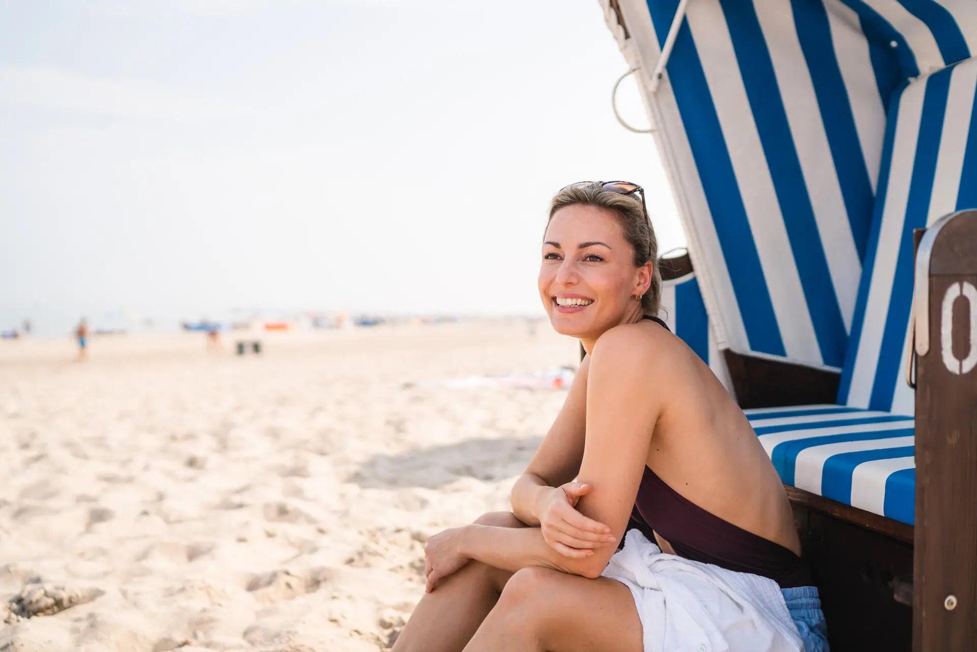 A woman sits in a beach chair.