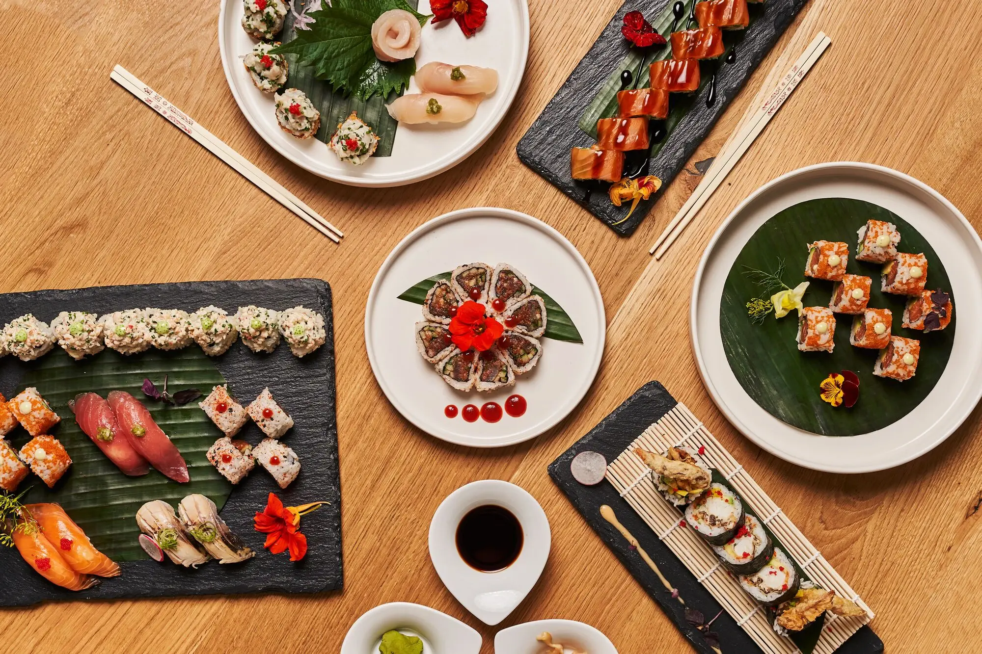 A table photographed from above with plates full of sushi.