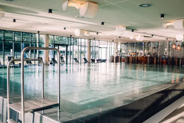 A large indoor swimming pool with clear water and modern architecture.