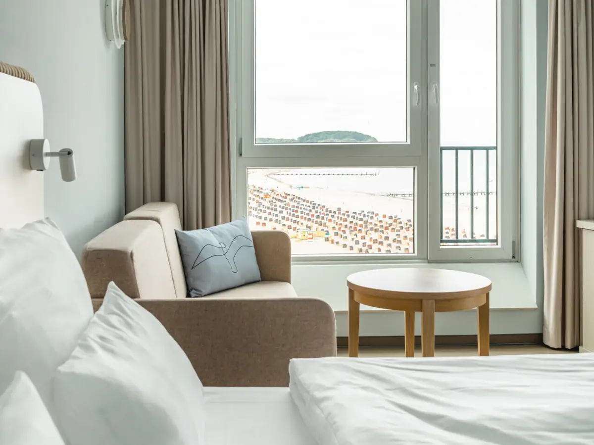 Rooms at the aja Travemünde A room with a bed and a sofa.