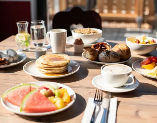 A table with plates full of food and drinks.