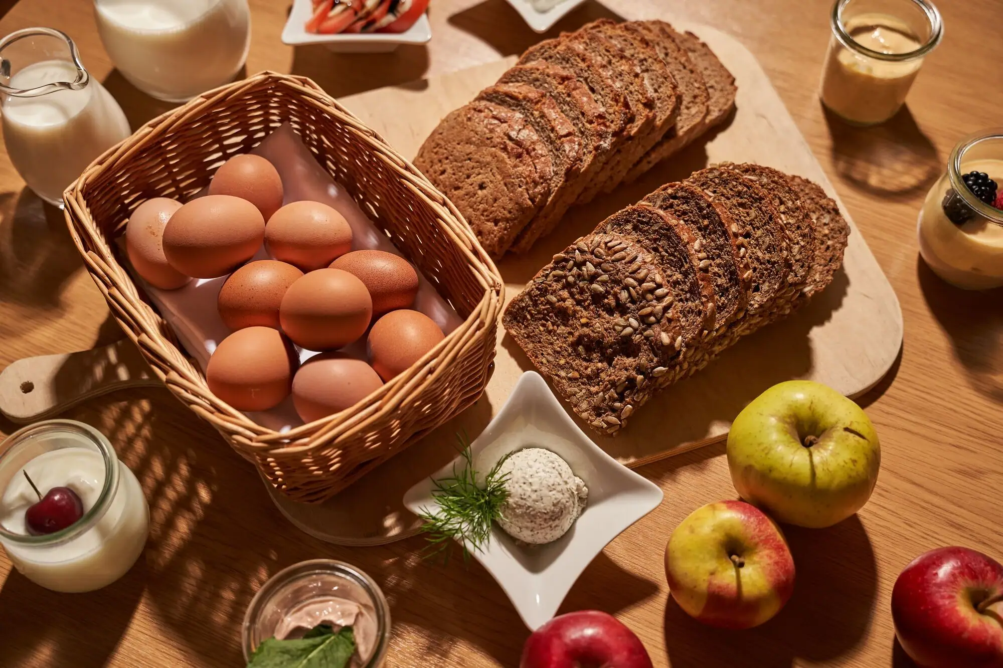 Breakfast A basket of eggs and bread on a table.