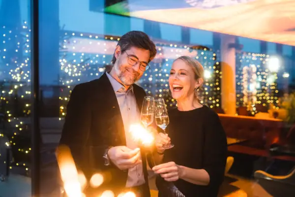 New Year’s Eve at the aja Travemünde A man and a woman are holding champagne glasses and sparklers