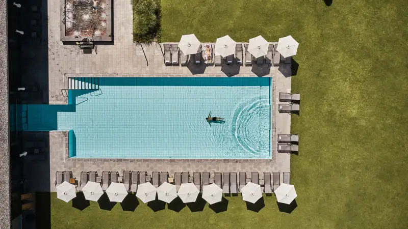 Pool from above Swimming pool with parasols and lawn.