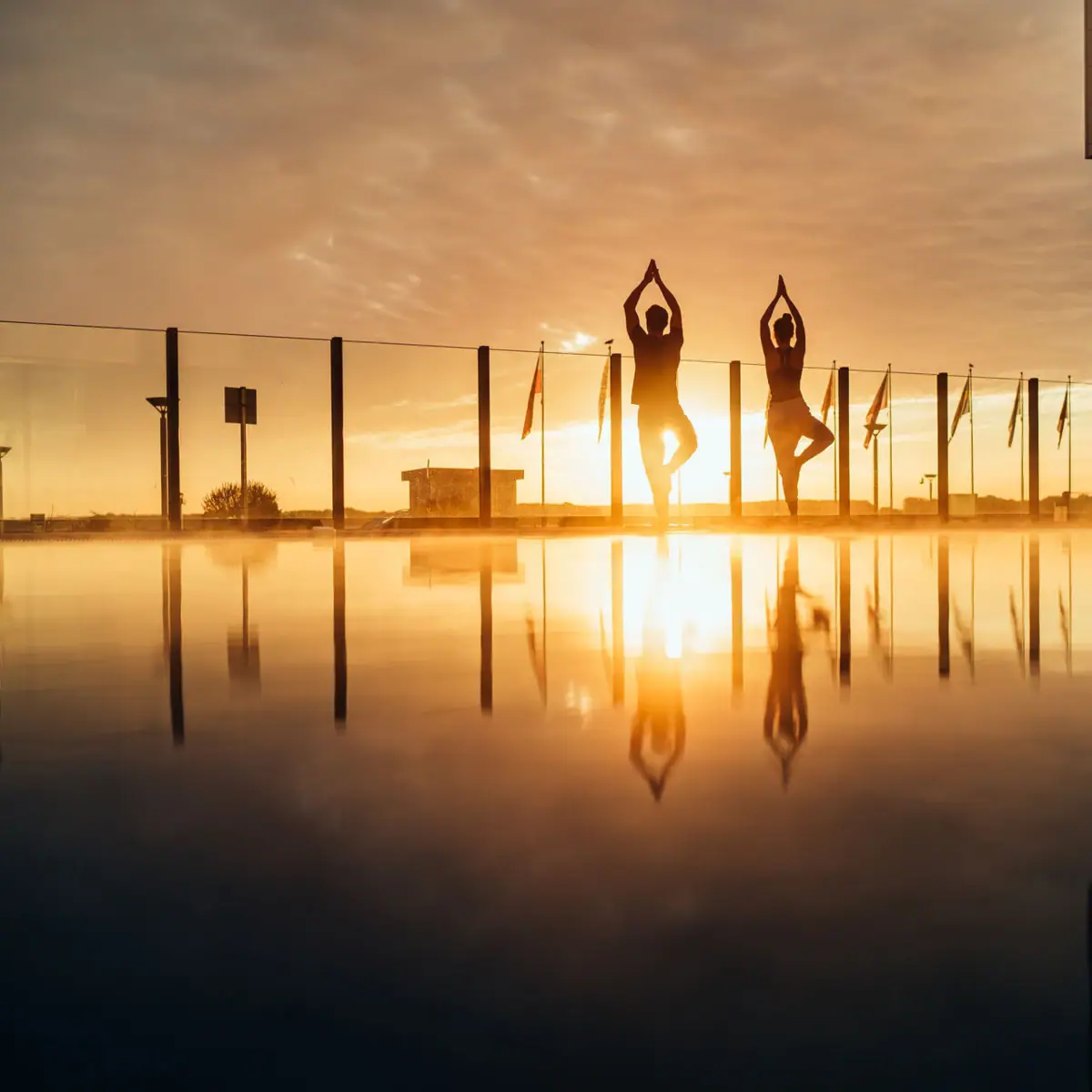 Fitness at aja  A group of people stand in the water of a pool with their hands raised.