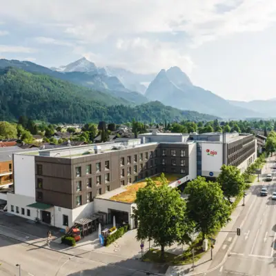 A building with trees and mountains in the background.