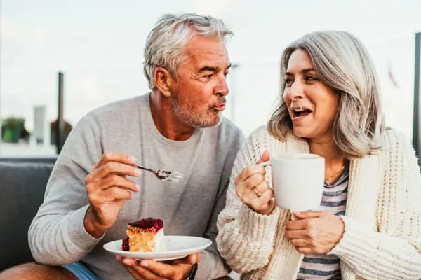 A man and a woman are eating cake.