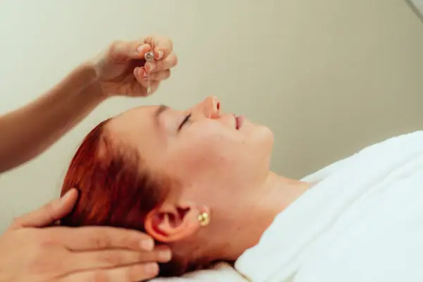 A woman is having a facial massage.