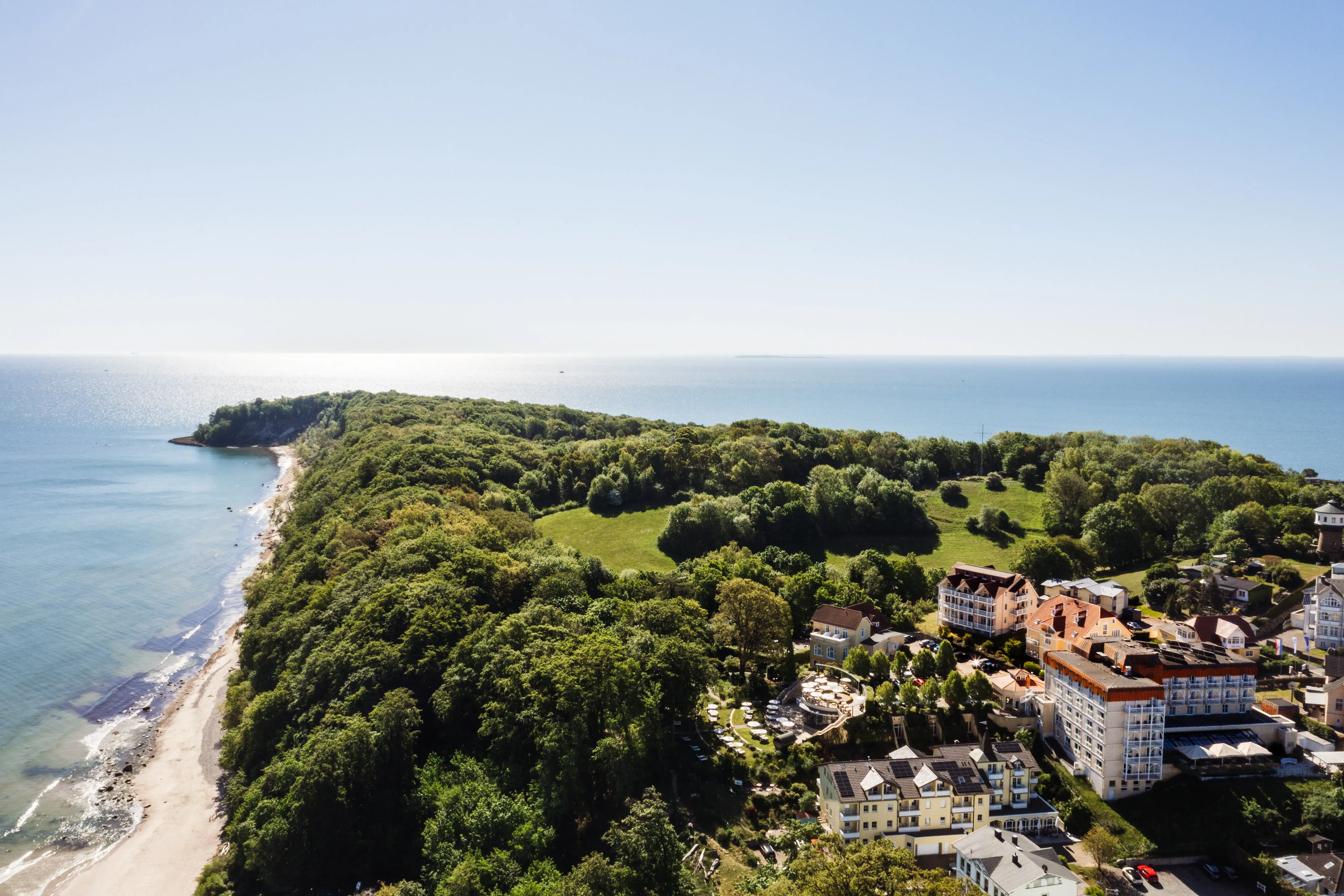 North horse Landscape with trees and buildings on the coastal strip, blue sky in the background.